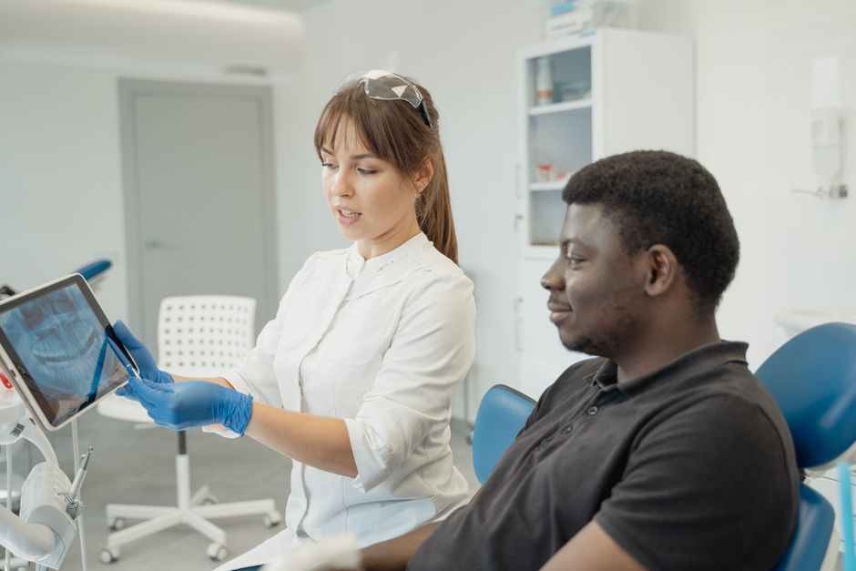 Dentista e paciente analisando uma radiografia