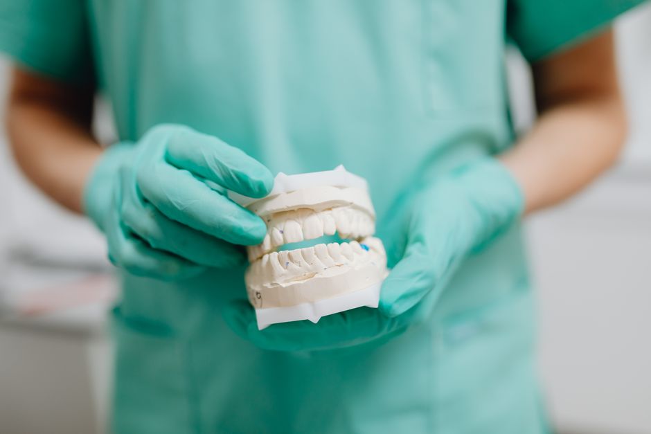 Dentadura completa segurada na mão